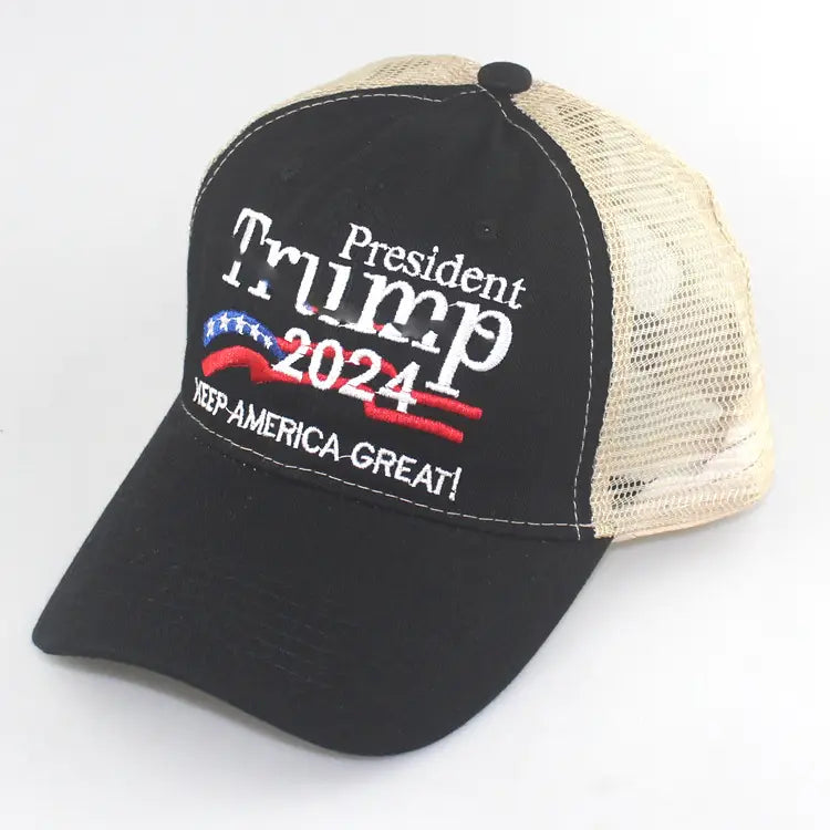 Black and beige trucker hat featuring embroidered president trump 2024 text american flag motif and keep america great slogan.