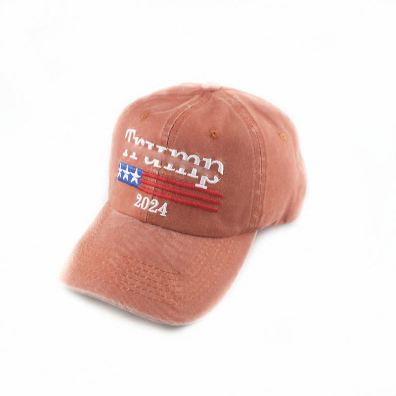 A faded rust-colored trucker hat with embroidered white trump 2024 text and a stylized American flag design.