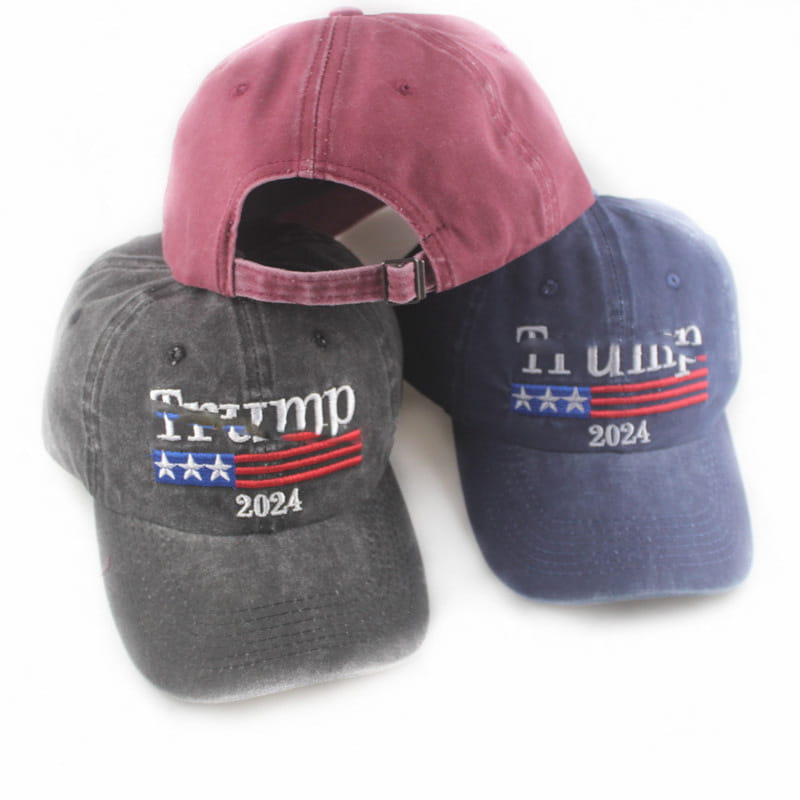 Three distressed cotton baseball caps in maroon gray and navy blue featuring embroidered Trump 2024 logos with stars and stripes are shown as Trump 2024 embroidered trucker hats.