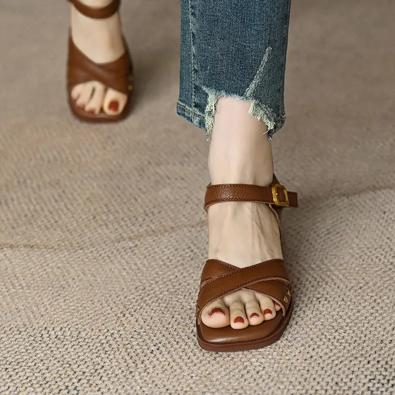 sandalias retro de tacón medio de cuero francés para mujer color marrón, con diseño de tira cruzada y hebilla de tono dorado.