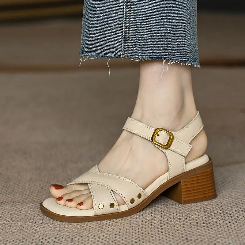sandalias retro de tacón medio de cuero francés para mujer color crema, con tacón bloque de madera robusto, hebilla de tono dorado y tachuelas decorativas.