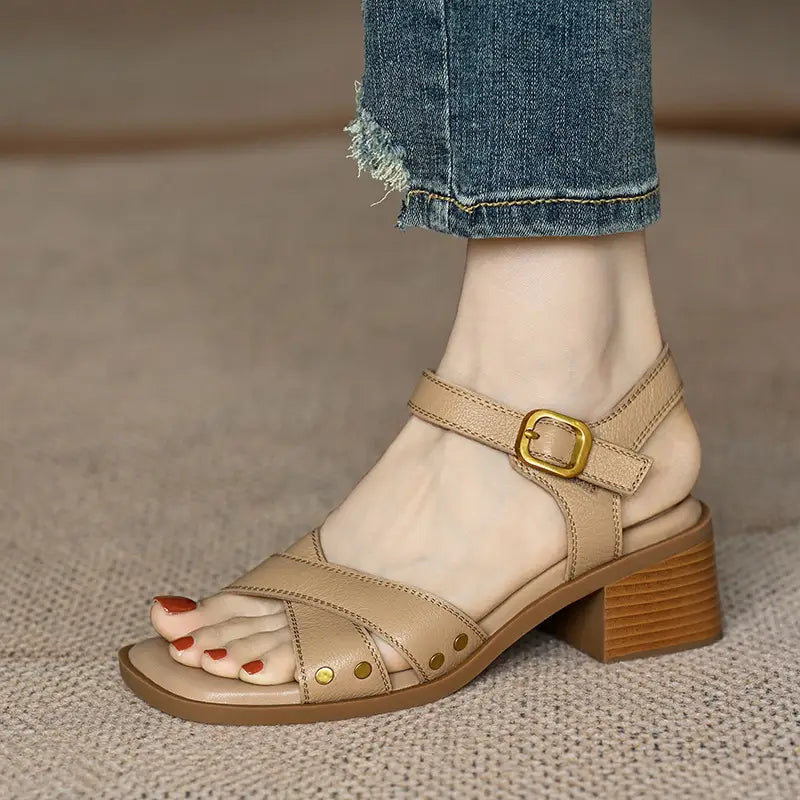 sandalias retro de cuero francés para mujer color beige, con tacón bloque de madera robusto de altura media, hebilla de tono dorado y tachuelas decorativas de latón.