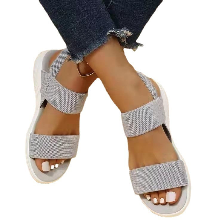 Back side view of flyknit elastic back strap flat sandals for women featuring light gray textured fabric straps and a white rubber sole.
