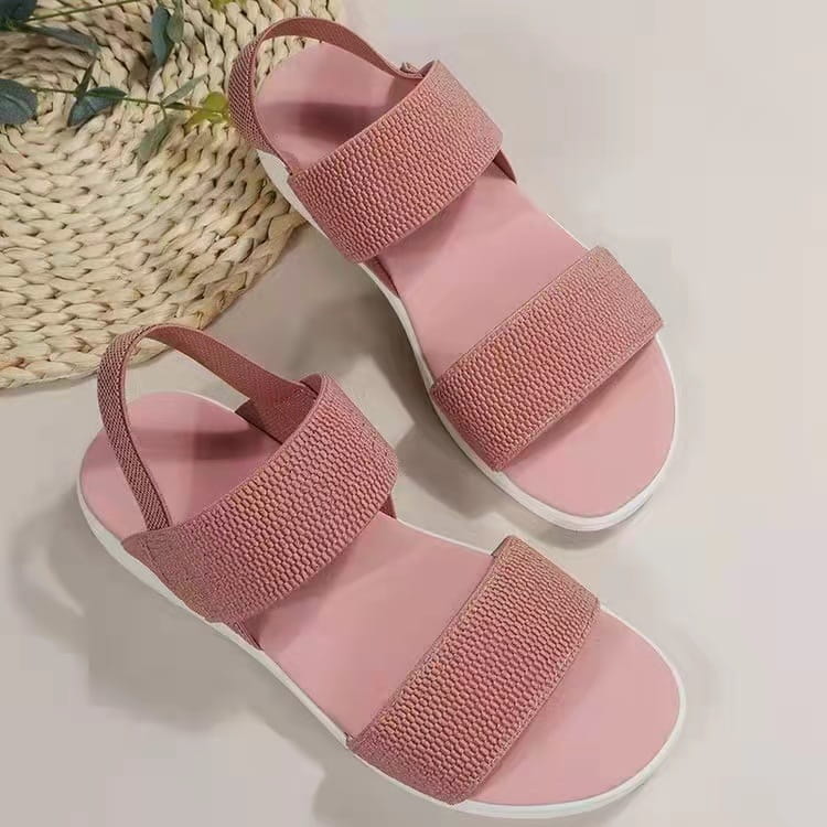 Pink flyknit woven strap flat sandals for women with elastic back strap and white sole.