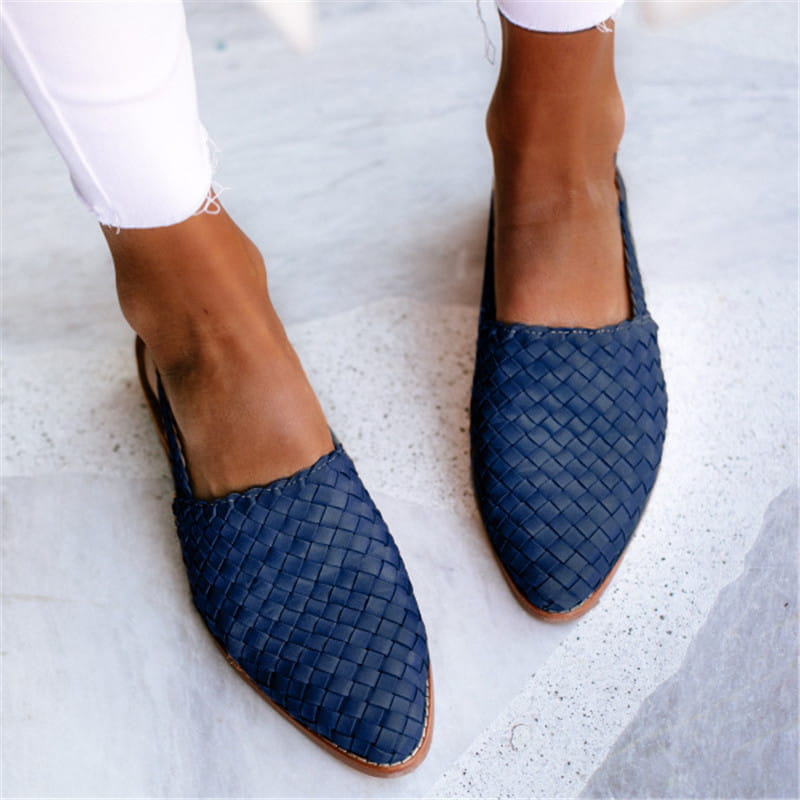 Navy blue woven leather pointed toe buckle flat mule sandals with tan soles viewed from the back.