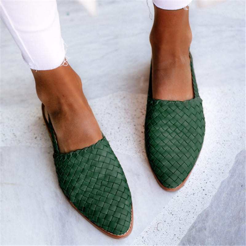 Green woven leather pointed toe flat mule sandals with a light brown sole and buckle detail