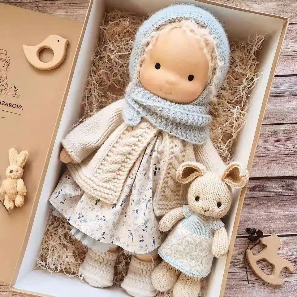 Handgemachte Plüschpuppe mit goldenen lockigen Haaren, 30 cm, mit einer weichen handgestrickten Holzpuppe mit hellem Hautton sowie einer hellblauen gestrickten Haube und einem Schal.