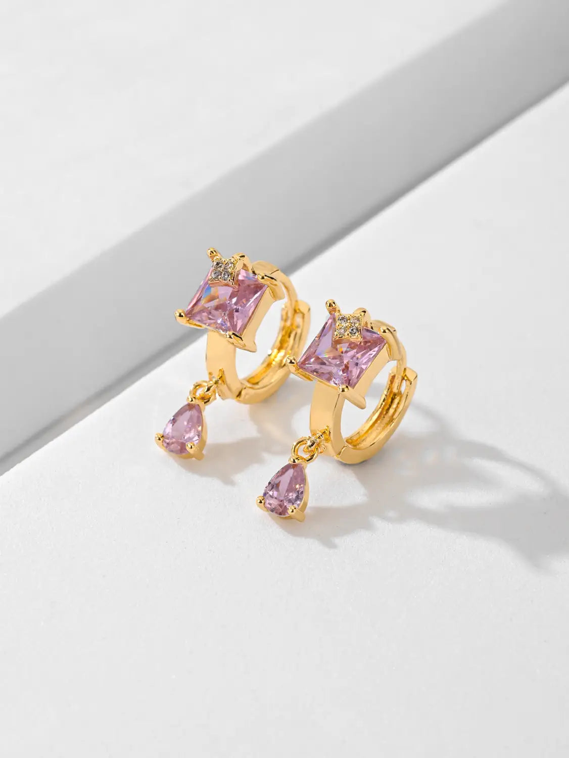 Des boucles d’oreilles créoles goutte en pierre précieuse géométriques élégantes en or, présentant des pierres carrées roses et en forme de goutte, avec de minuscules accents de diamant.