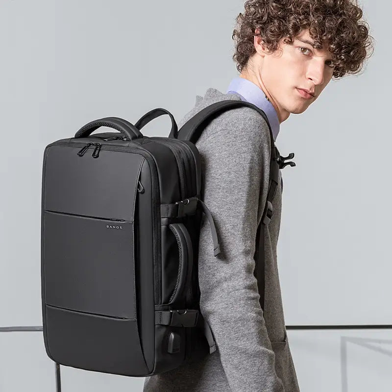 Black Bange 16 inch waterproof laptop travel backpack with sleek minimalist design and durable fabric construction viewed from the back side.