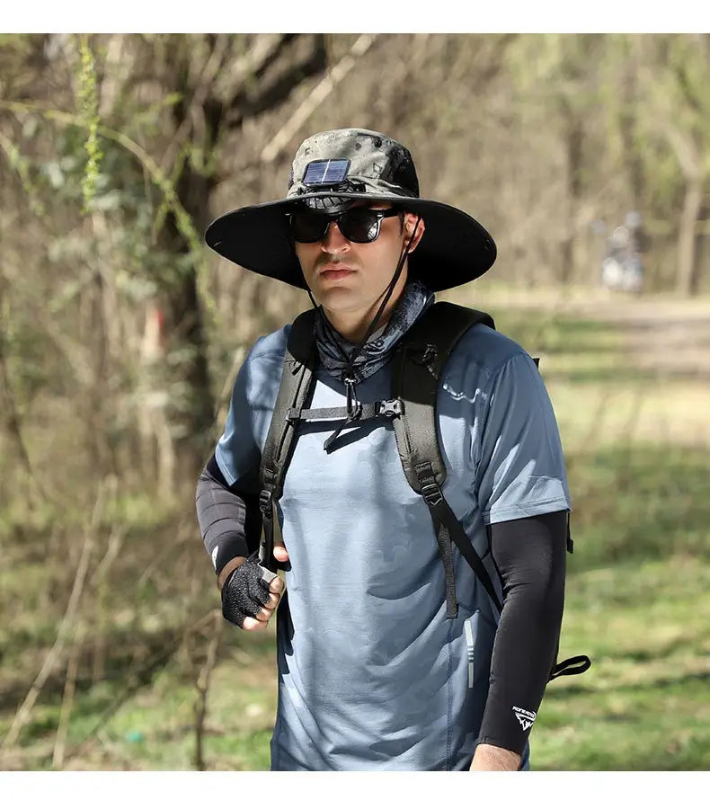 Camouflage-patterned solar fan sun hat with a black brim and a small solar panel on the crown designed for outdoor fishing.