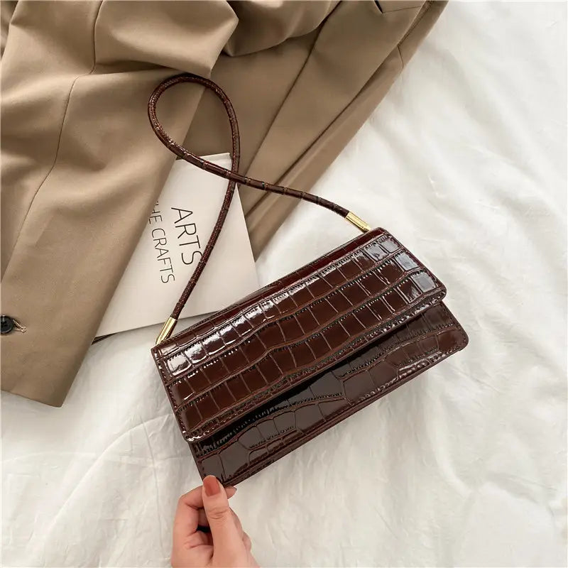 Brown crocodile-embossed high-end pu clutch underarm bag with a slender shoulder strap and gold-tone hardware.