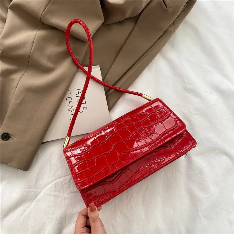 Vibrant red croc-embossed PU clutch with glossy finish and gold-tone hardware designed as a high-end underarm bag with crocodile pattern.