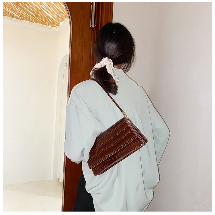 Brown crocodile-textured crossbody bag with gold-tone hardware accents made of high-end PU for use as a clutch or underarm bag.