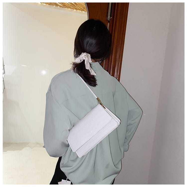 White textured crocodile pattern underarm bag with gold-tone zipper pull made of high-end pu leather designed as a crossbody clutch.