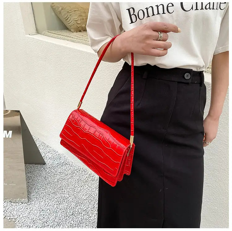 Vibrant red mini crossbody bag with croc embossing and gold-tone hardware made of high-end pu material designed as an underarm clutch.