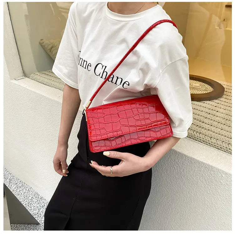 Vibrant red crocodile-embossed high-end Pu clutch bag with a sleek glossy finish and gold-tone hardware designed as an underarm bag.