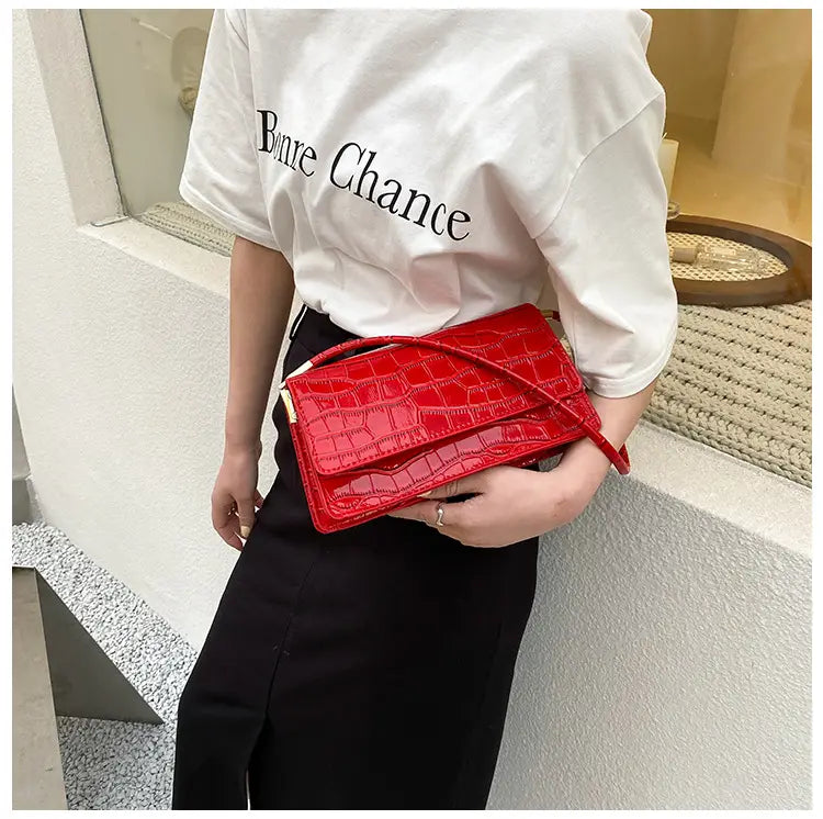 Vibrant red croc-embossed underarm bag clutch with a sleek glossy finish and gold-tone hardware made of high-end pu material.