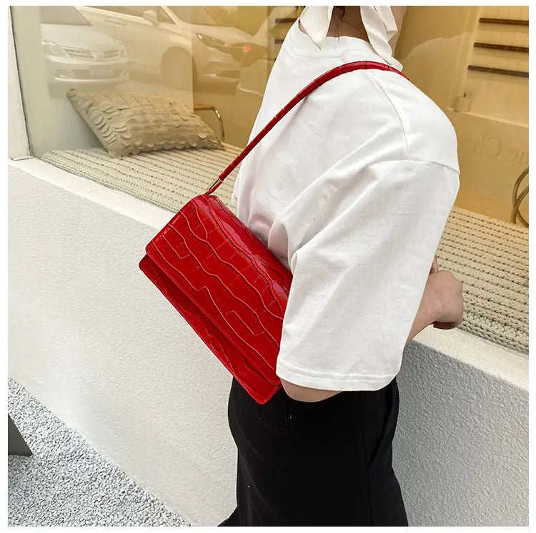 Vibrant red croc-embossed underarm bag made of high-end pu material with a sleek glossy finish and matching shoulder strap.