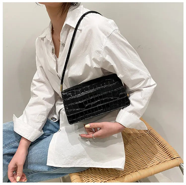 Black crocodile-embossed underarm bag with a sleek rectangular design made of high-end PU and featuring gold-tone hardware.
