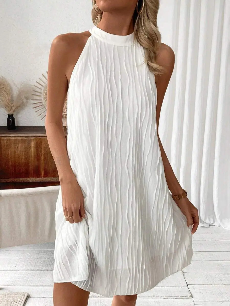A white pleated sleeveless halter neck dress for women with a flowing texture shown from the front.
