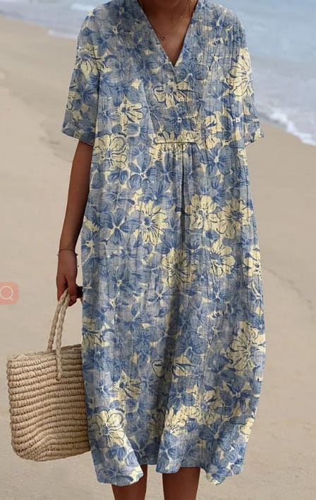 A flowing blue and yellow floral print loose maxi dress with short sleeves and a v neckline.