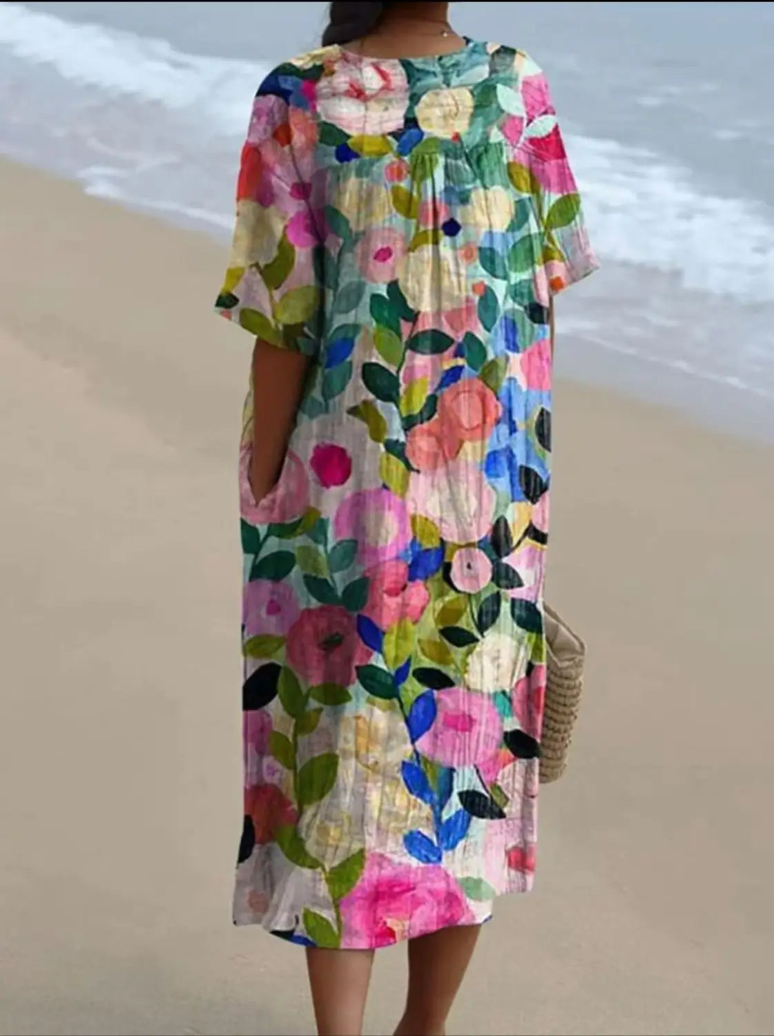 A vibrant floral print v neck loose midi dress with a relaxed fit short sleeves and gathered neckline in soft pastel and bold hues of pink blue green and yellow.
