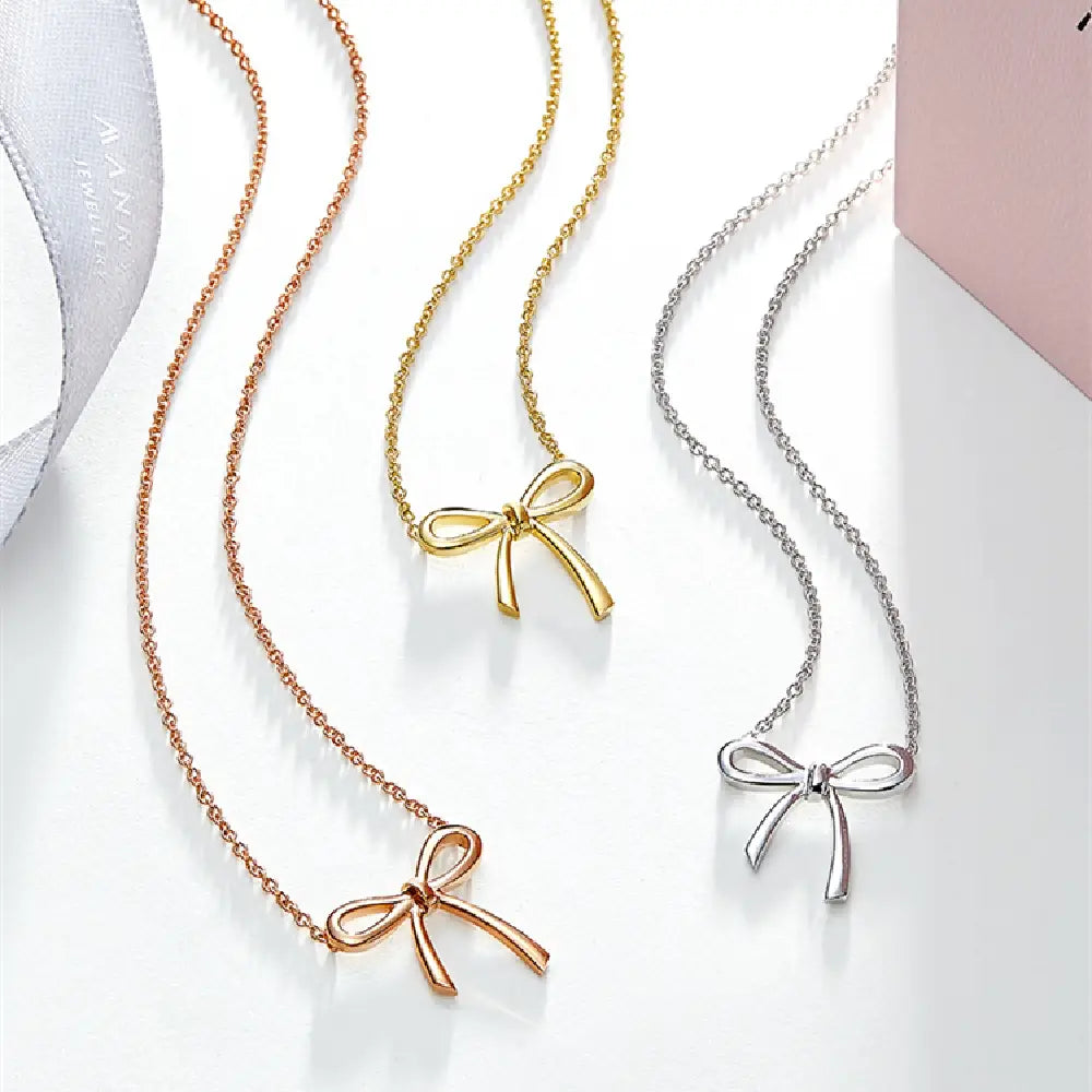 Three delicate Korean style bow pendant clavicle necklaces in rose gold, yellow gold, and silver tones with fine chain links.