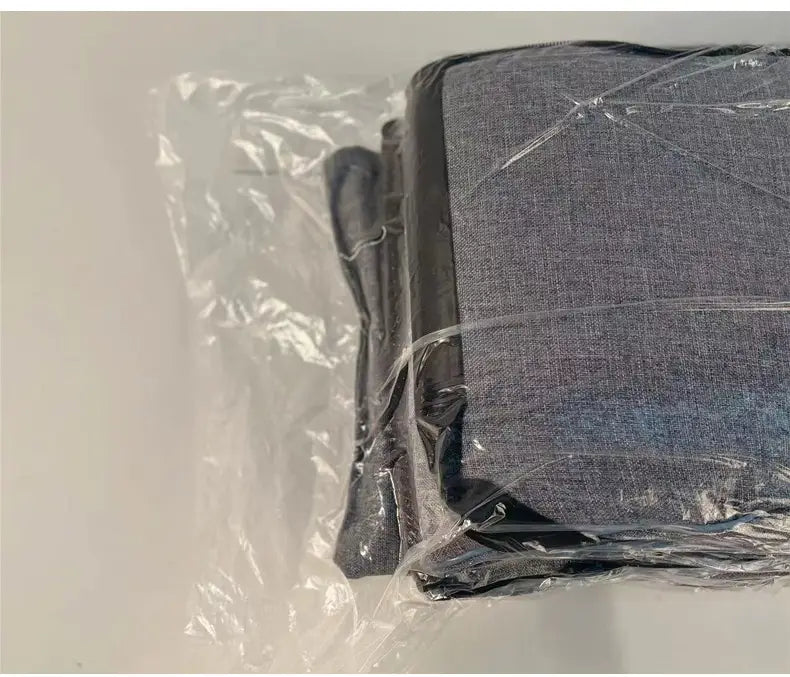 Grau strukturierter Stoff für eine Polsterauflage, umwickelt in klarem Kunststoff für einen Hundesitz im Auto und eine Transportbox für Haustiere.