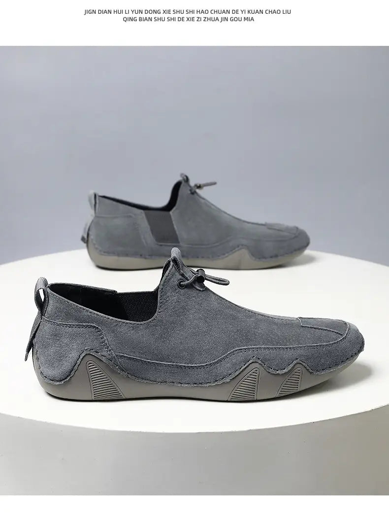 Gray suede breathable slip on leather loafer with a textured rubber sole and subtle stitching details for casual use.