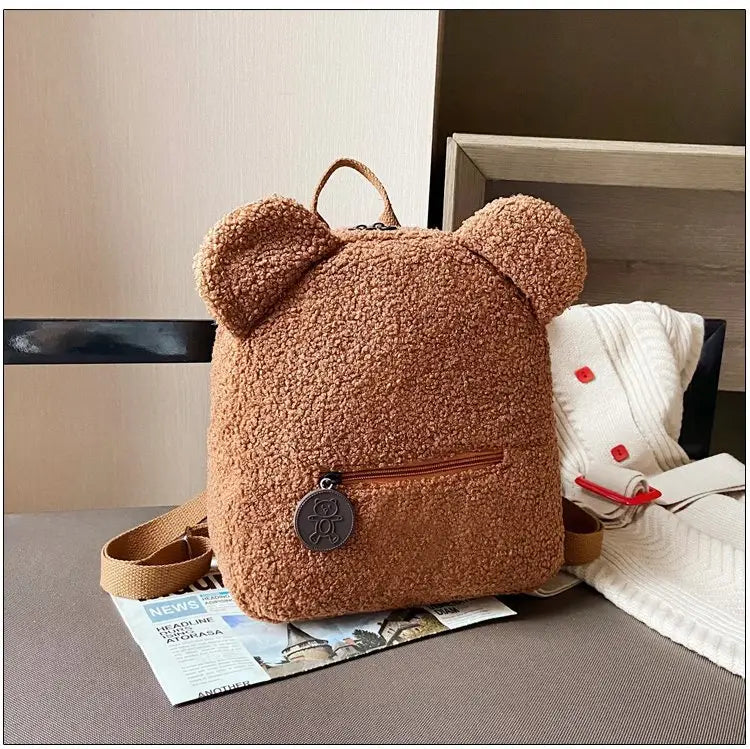 cute brown bear shaped plush backpack with fuzzy fleece texture and rounded ears designed as a rucksack