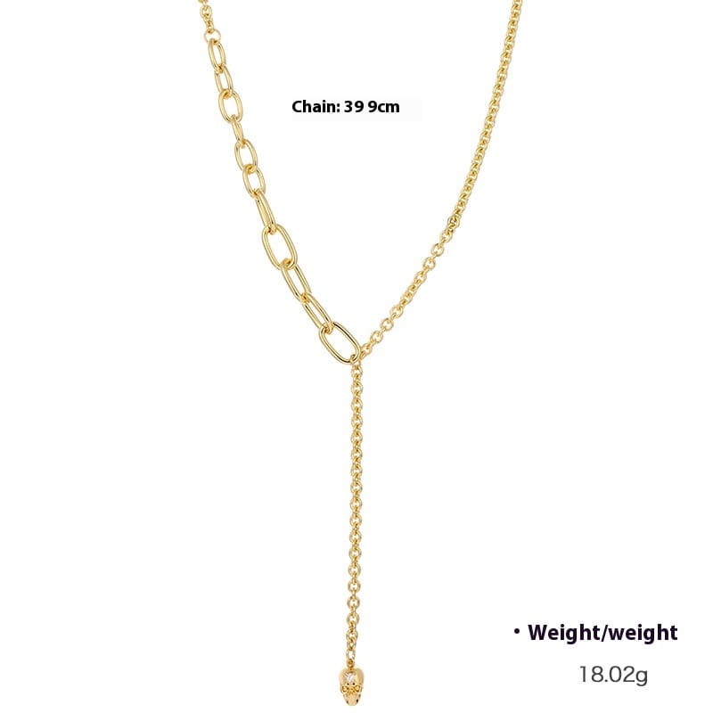 gold-toned y-shaped chain necklace with a dangling skull pendant featuring zirconium accents and pearl details in a punk style.