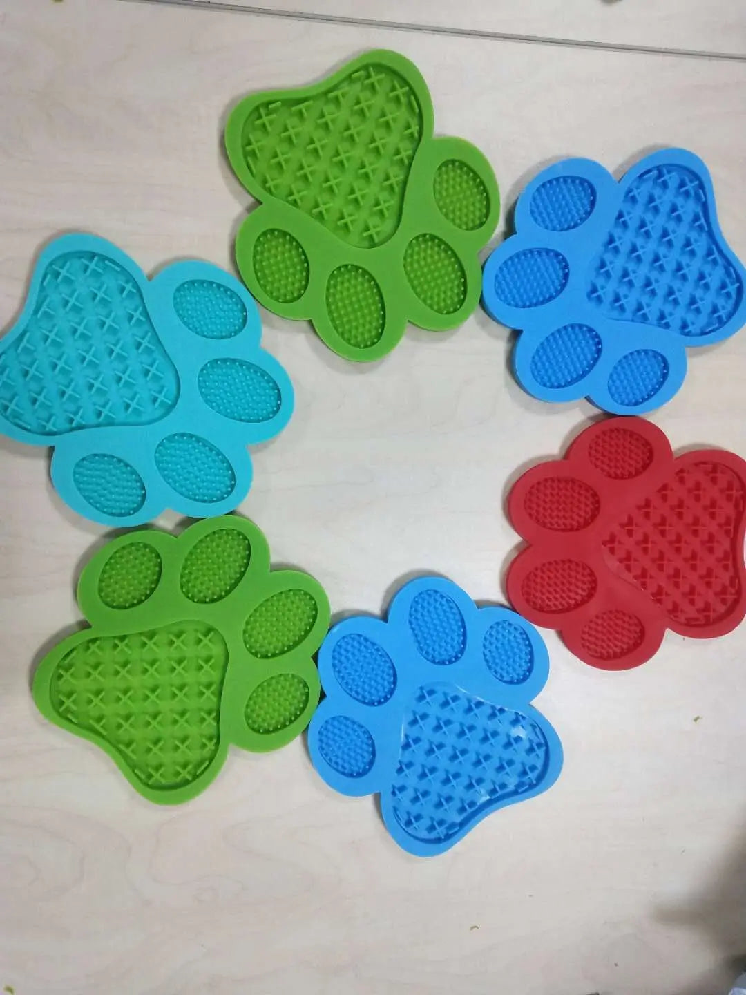 silicone dog bath lick pad grooming mats in colorful green blue and red silicone shaped like paws for pet grooming and grooming support