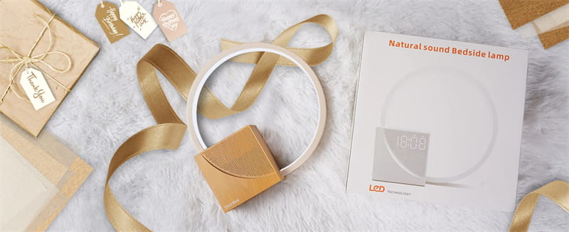 A sleek circular led bedside lamp with alarm clock and natural sounds featuring a minimalist design and warm gold accents.