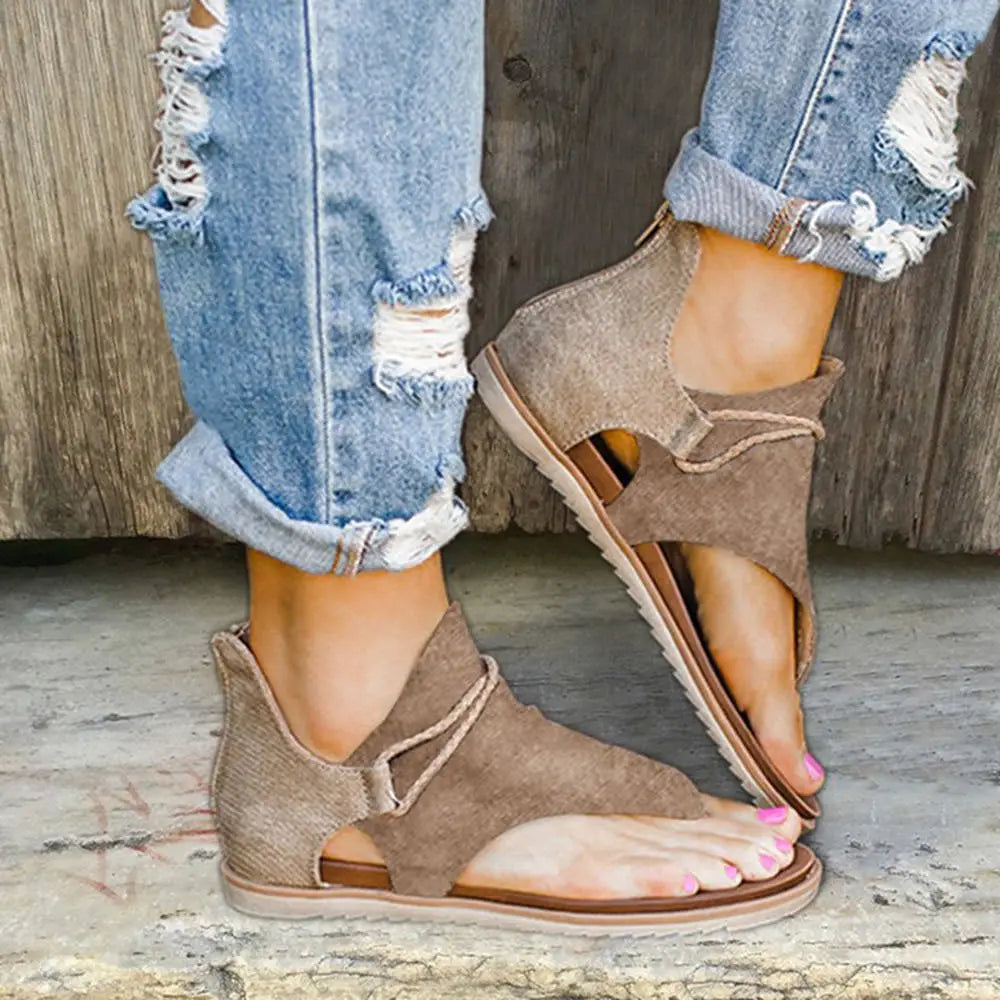 Tan suede women sandals featuring flat sole, animal print flat thong design, and adjustable ankle strap.