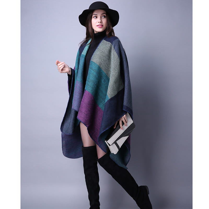 Une cape en laine à carreaux surdimensionnée élégante avec un motif géométrique multicolore bleu marine, bleu-vert, violet et gris, parfaite comme étole de voyage.