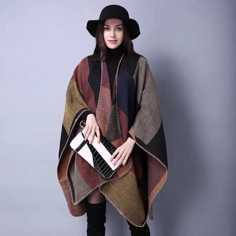 Un poncho en laine surdimensionné élégant avec un design géométrique en patchwork aux tons naturels de brun, noir et beige, idéal comme étole de voyage.