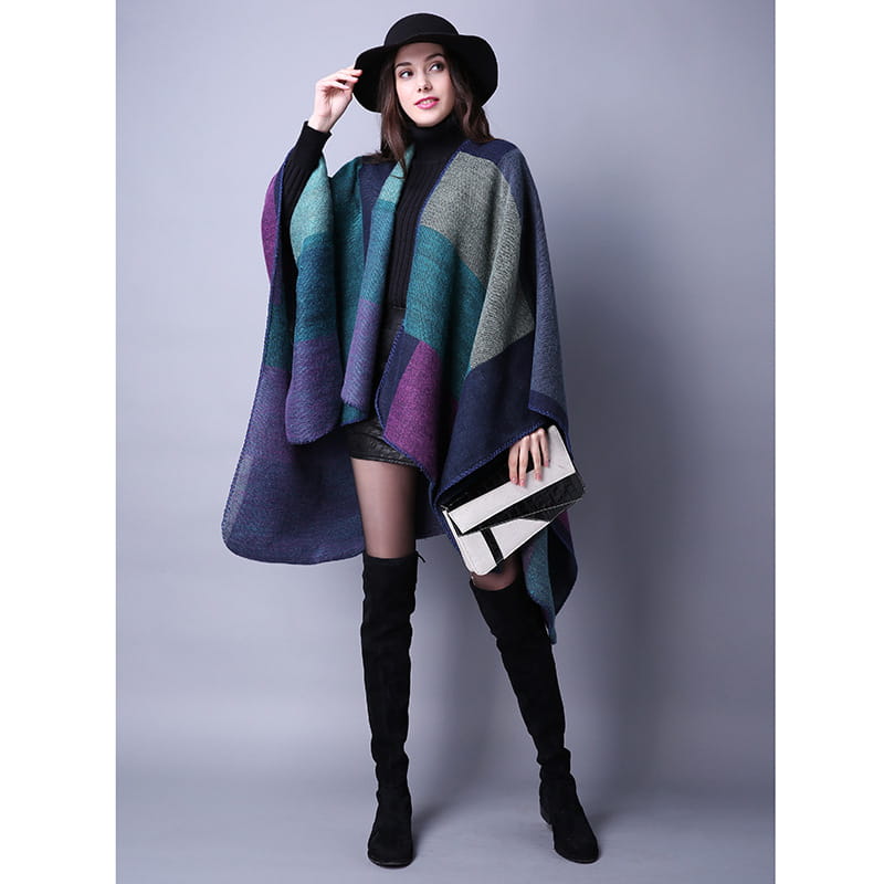 Cape en laine à carreaux surdimensionnée élégante avec un motif géométrique dans des nuances de violet, bleu-vert et bleu marine, conçue comme étole de voyage.