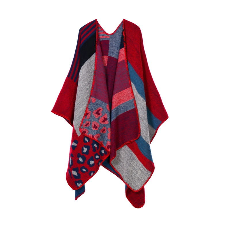 Cape en laine surdimensionnée à carreaux patchwork rouge vif, gris et bleu marine avec des accents de motif léopard, conçue comme étole de voyage géométrique.