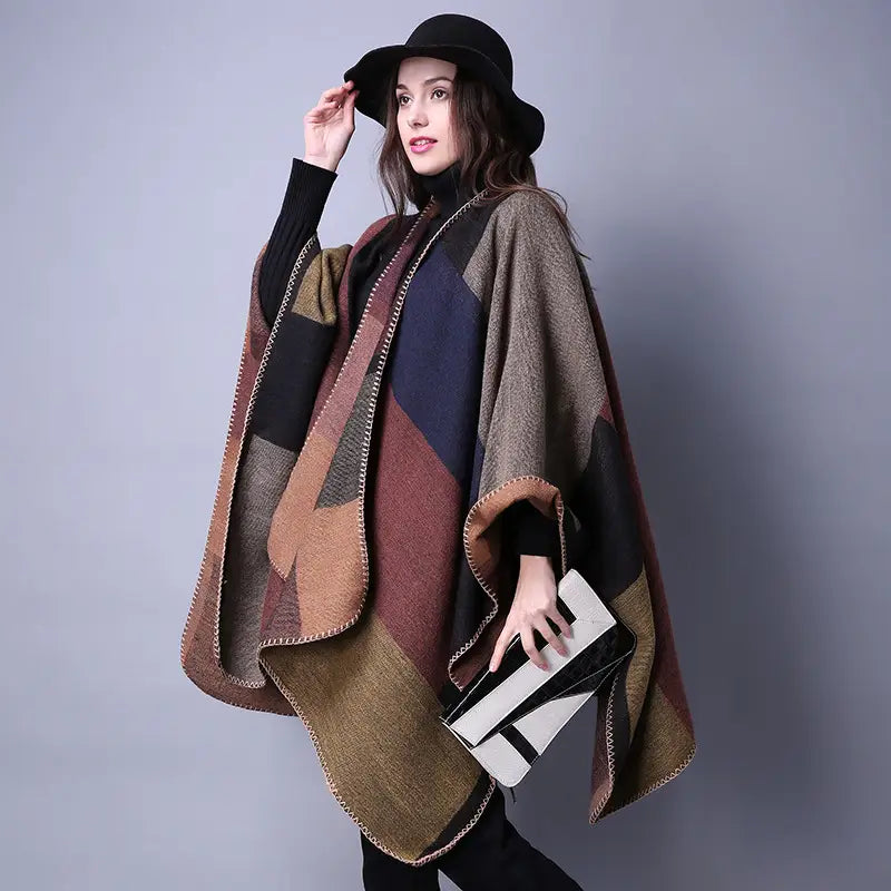 Cape en laine à carreaux surdimensionnée élégante, avec un motif en patchwork géométrique aux tons naturels de brun, beige et bleu marine, adaptée comme étole de voyage.