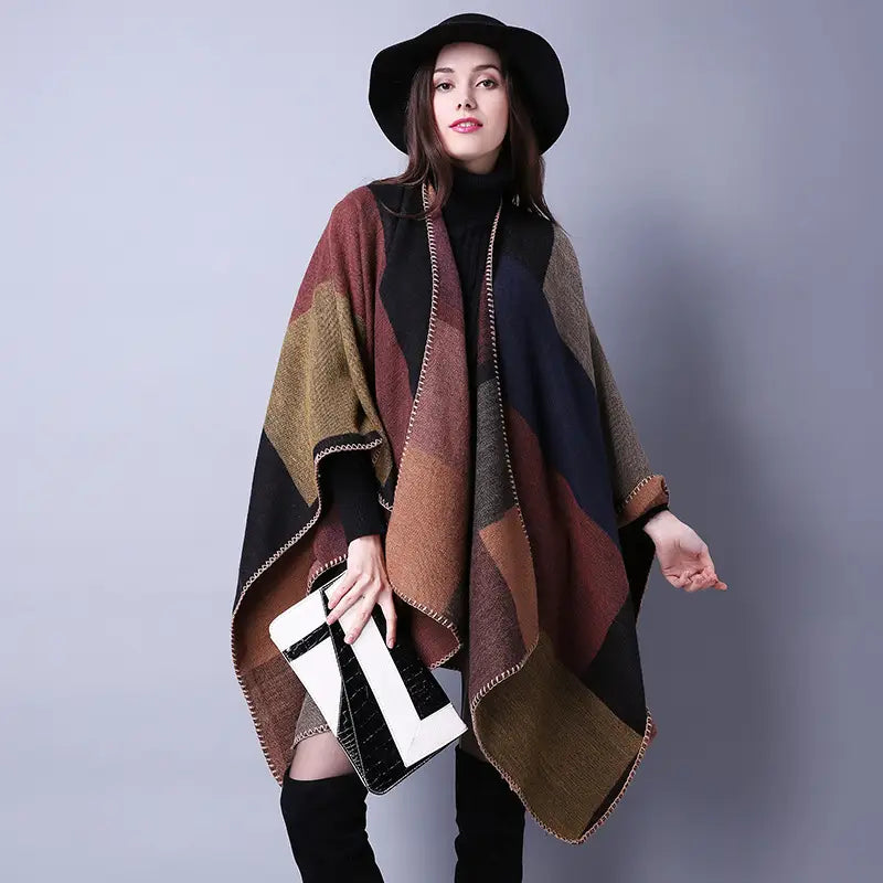 Cape en laine à carreaux surdimensionnée douillette, présentant un motif géométrique en patchwork aux tons naturels de brun, noir et vert olive, adaptée comme étole de voyage.
