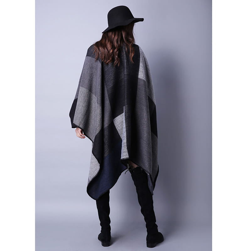 Cape en laine à carreaux surdimensionnée pour voyage géométrique élégante en noir, gris et bleu marine, avec un tissage texturé et un motif géométrique.