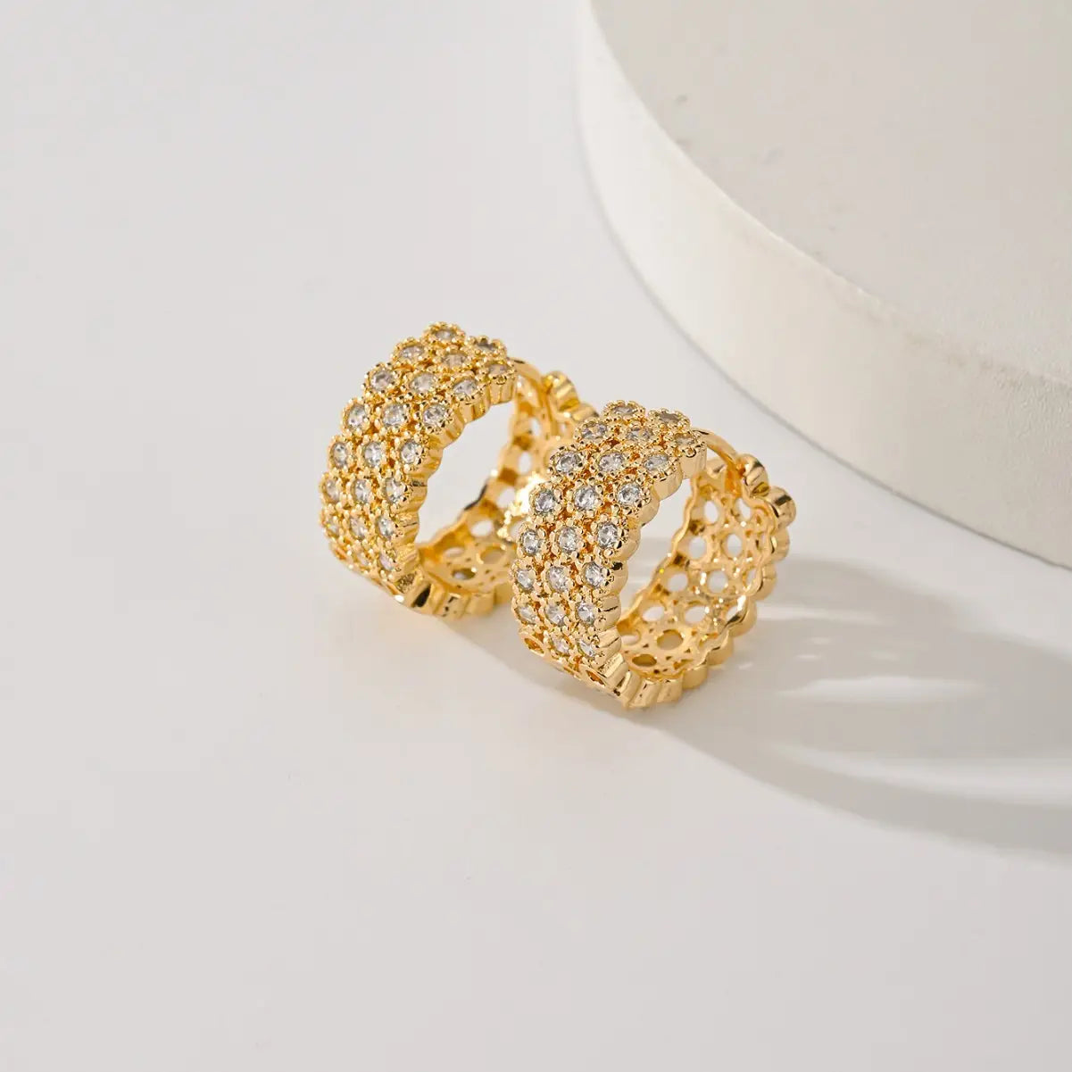 Ausgefallene goldfarbene Goldschmiedearbeit-Crystal-Ohrreife mit goldgetöntem Metall, funkelnden klaren Kristallen und zarten spitzenartigen Aussparungen.