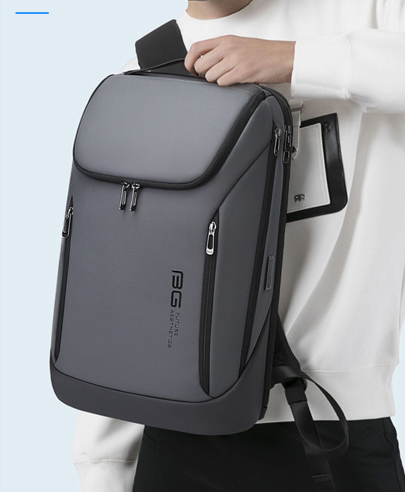 Gray and black men’s laptop travel backpack with multiple zippers, a side pocket for phone or tablet, usb charging port, and brand logo on the front.