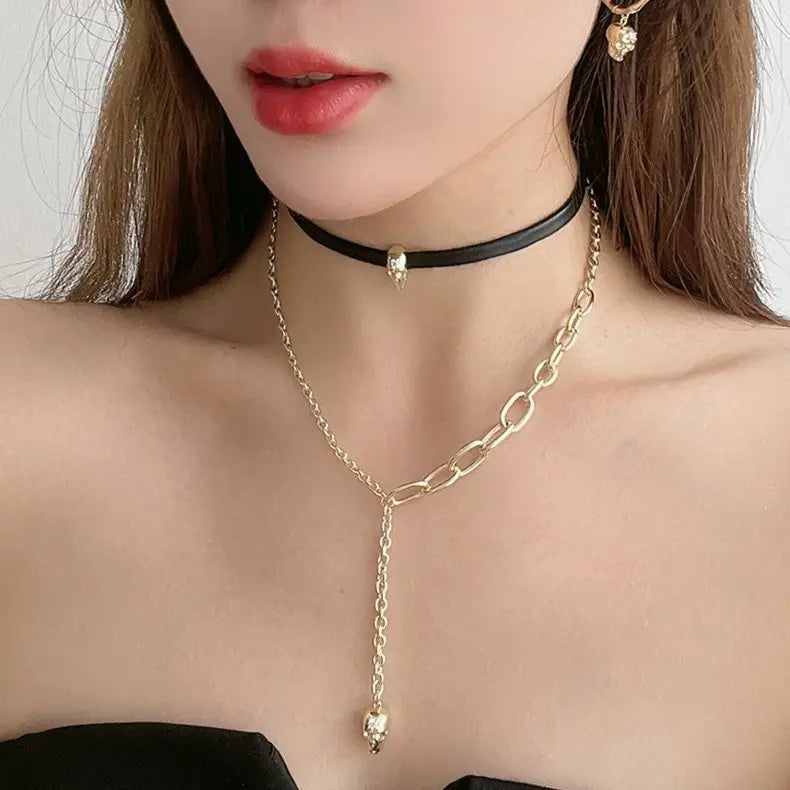 collar tipo choker de cadena de oro con colgante de calavera y collar de cuero negro, combinado con aretes de borla de calavera de oro con acentos de zirconio
