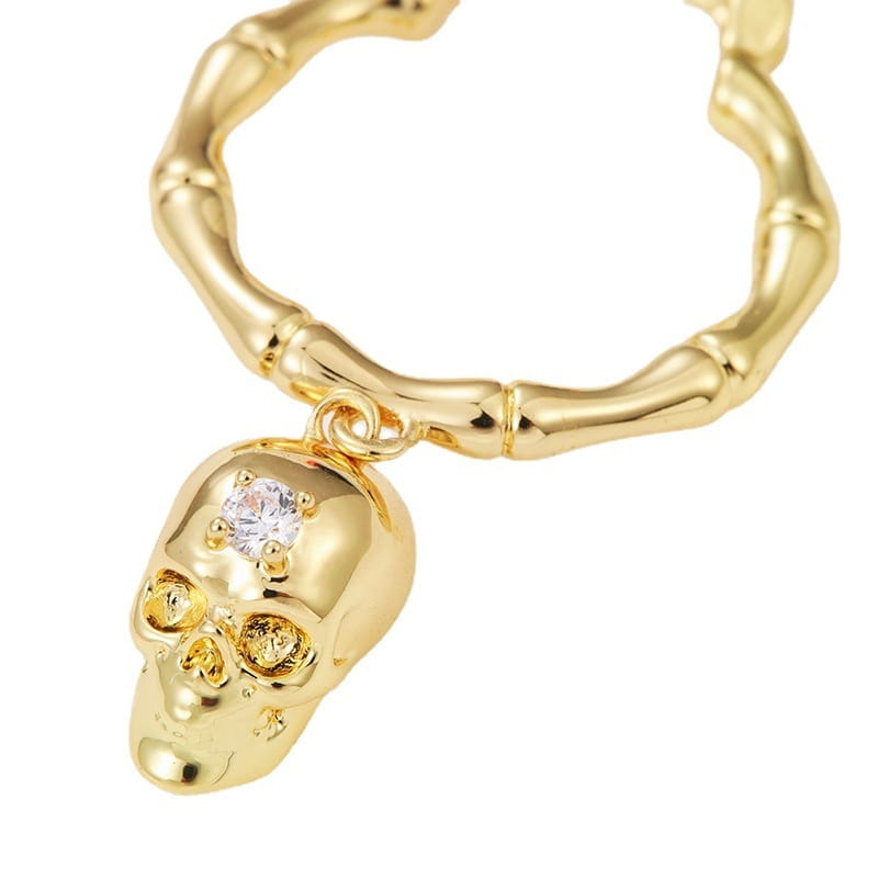 aretes de borla de calavera de oro con colgante de calavera de color dorado, cadena estilo bambú y un acento de cristal de zirconio transparente