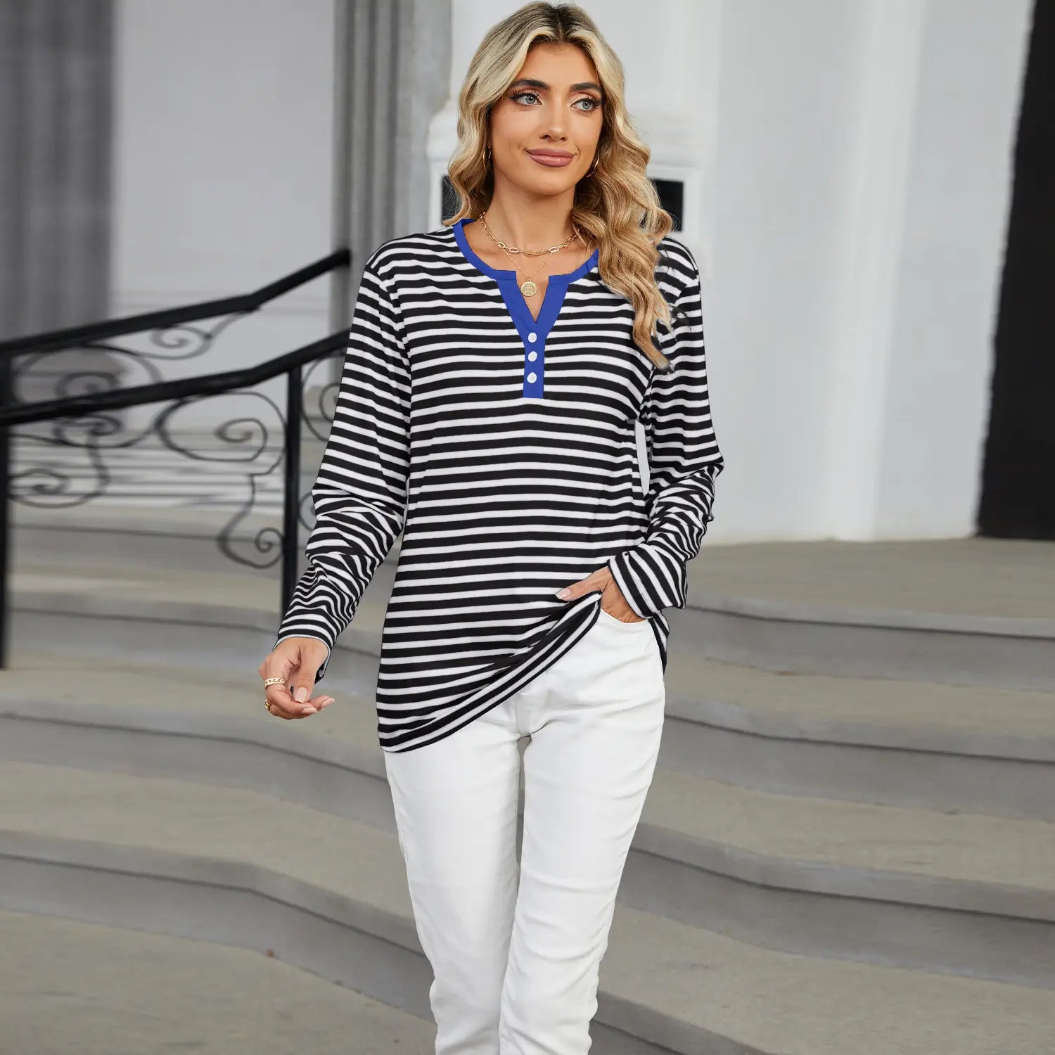 Black and white striped long-sleeved henley top with a blue collar and button placket suitable for casual wear.