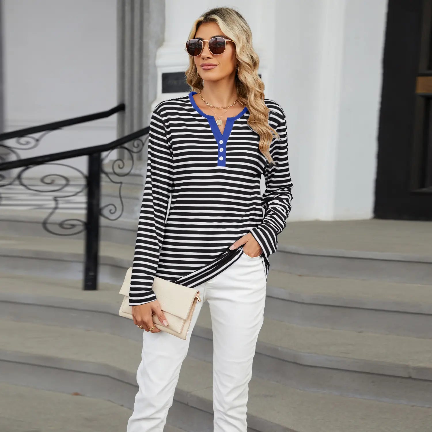 Black and white striped long sleeve henley t shirt with a v neck, contrasting blue collar, and three-button placket.