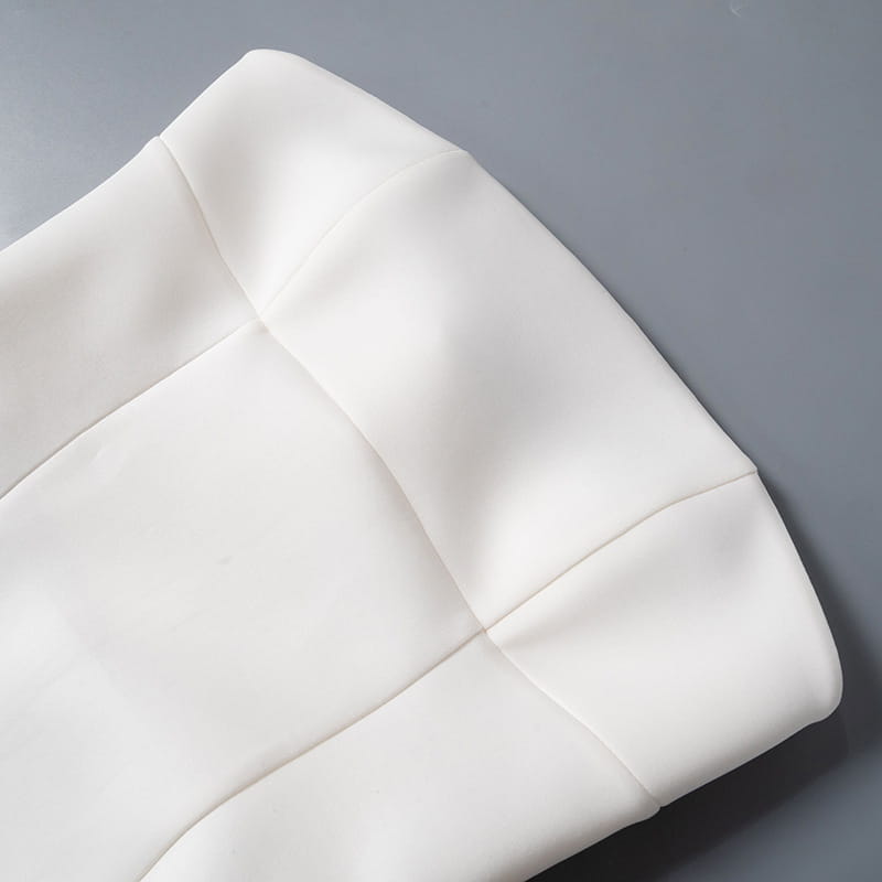 White quilted fabric with clean precise stitching and smooth texture on a women’s strapless a line mini dress with fitted bodice