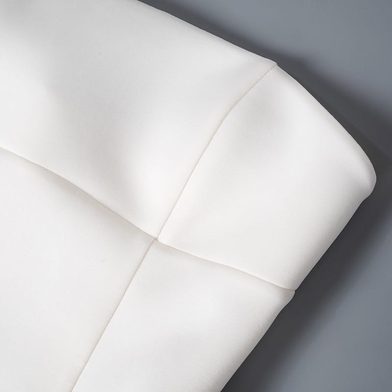 White faux leather cushion with clean stitched seams and a smooth slightly glossy finish paired with a women’s strapless a line mini dress with fitted bodice.
