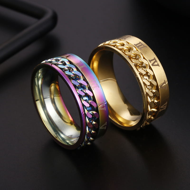 Two stainless steel spinner rings featuring a rainbow iridescent chain-link design and a gold-toned band with roman numerals engraved, part of the roman numeral spinner chain ring with bottle opener collection.